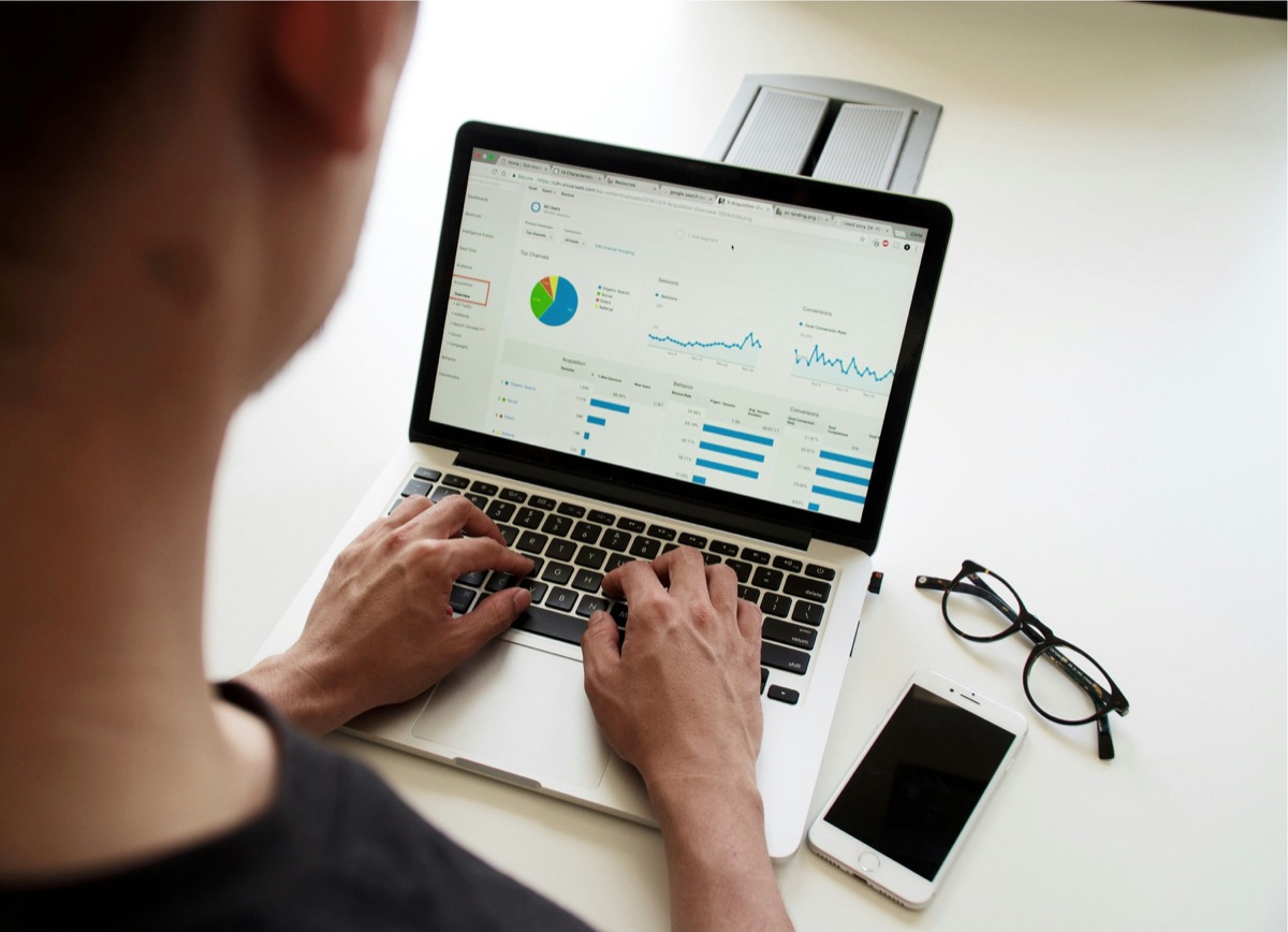 Marketing professional analyzing real estate market data on laptop